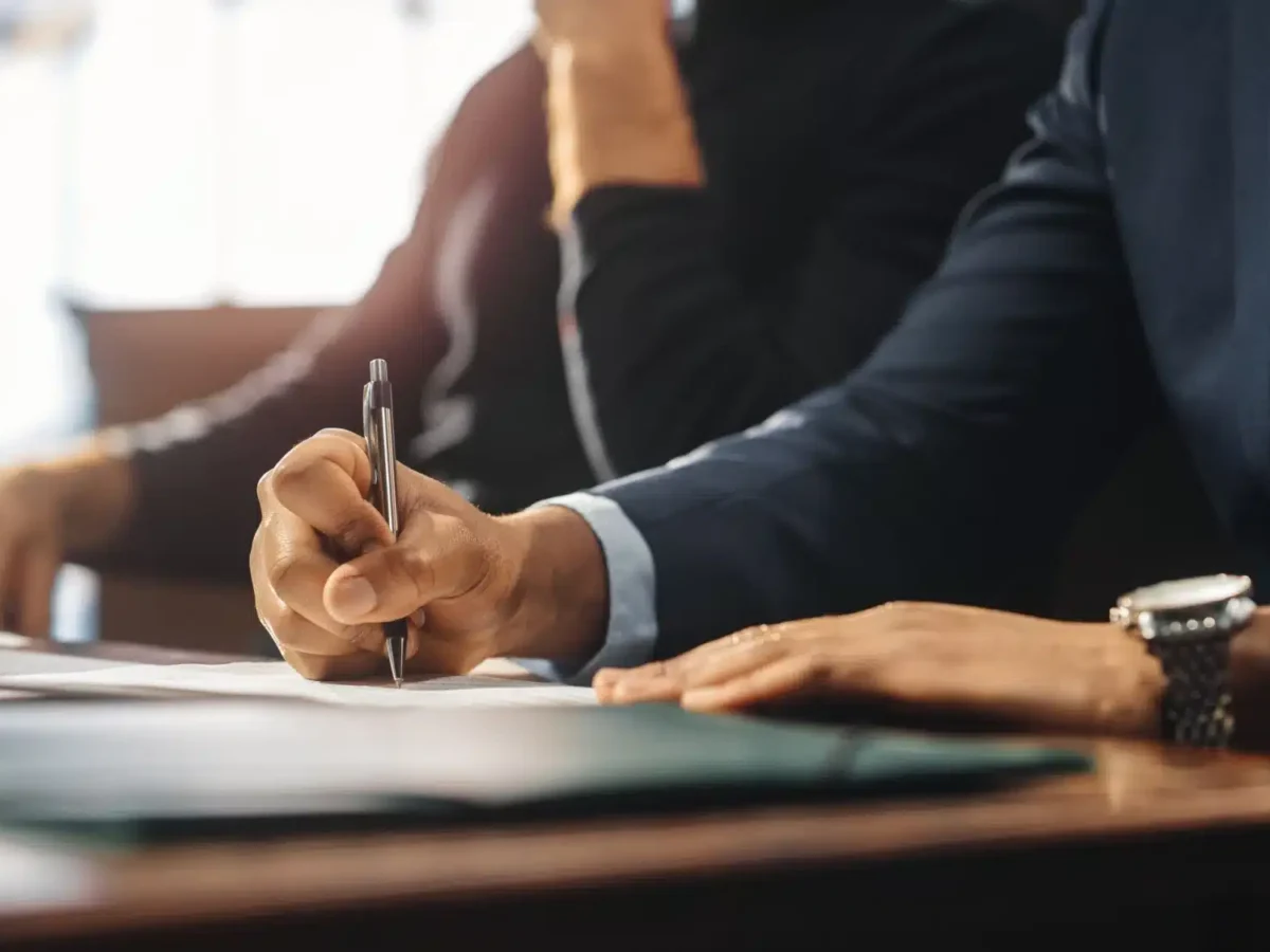 Person writing notes with a pen during a legal consultation, emphasizing the importance of defense strategies in DUI dismissal cases in Texas.